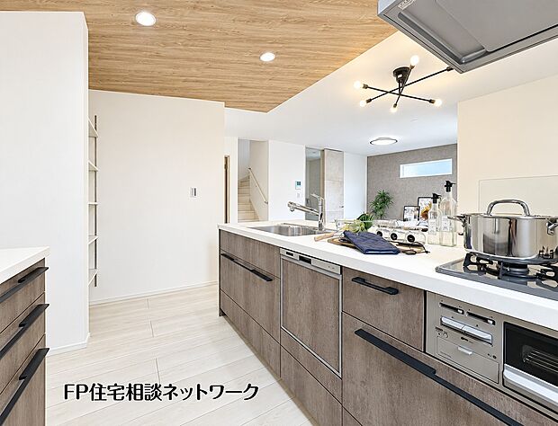 【キッチン】木目調の天井とこだわりの照明が、温かみのある空間を演出するキッチン。対面式で家族と会話を楽しめます。食洗機も付いており、家事もスムーズに。