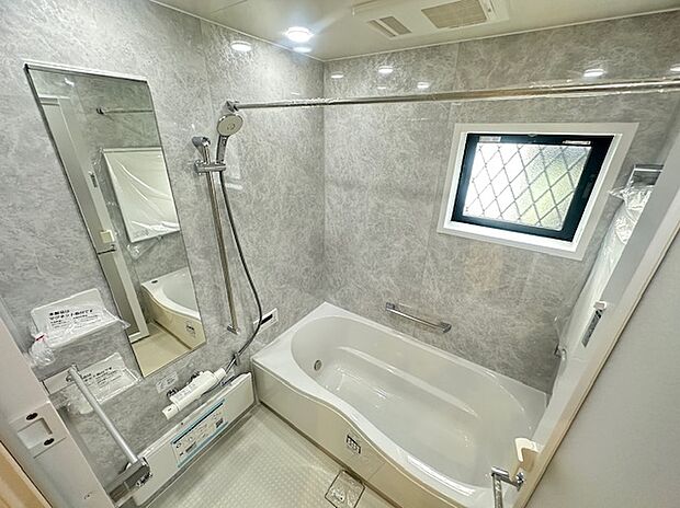 落ち着いたグレーの大理石調パネルが上質な印象を演出。大きな鏡とワイド浴槽で、ゆったりとした癒しの時間を過ごせます。