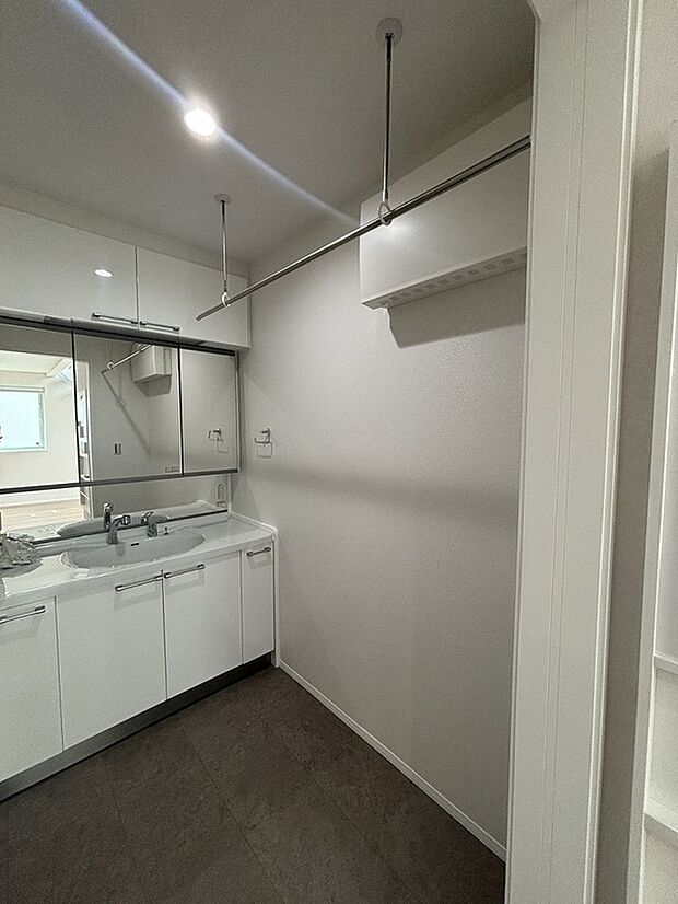 【洗面室。】幅120cmの洗面台は大きな三面鏡となっていて、2人で使っても広々。上下の収納でストックもたくさん置けます。取り外し可能な物干しスペースも。