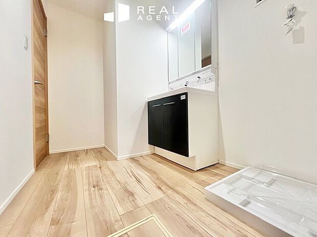 【B号棟洗面化粧台】洗濯機を置いても余裕のあるスペース。清潔感のあるパウダールーム、毎日何度も使う場所でもストレスなく使用できます。