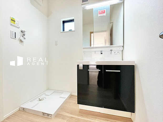 【C号棟洗面化粧台】洗濯機を置いても余裕のあるスペース。清潔感のあるパウダールーム、毎日何度も使う場所でもストレスなく使用できます。