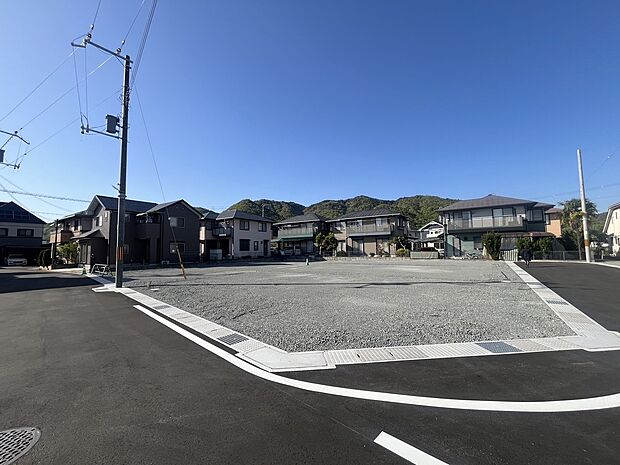【前面道路を含む現地】開けた敷地と、自然の潤いを身近に感じられるロケーション。整備された道路に面する、ゆとりある全15区画の分譲地で、ご家族らしい新しい住まいづくりを叶えます。