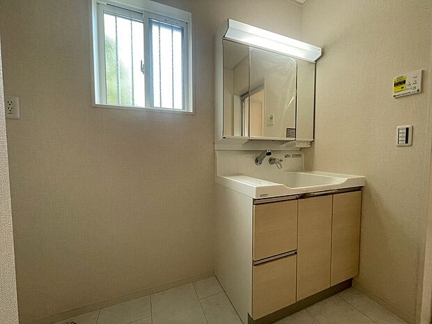 【【6号棟：洗面台】】ボウルとの一体型成形で継ぎ目のないハイバックガードと壁出し水栓は、汚れがたまりにくく、毎日のお手入れが簡単です。
可動式トレーなど、使いやすい収納も充実。（2025年6月2日撮影）
