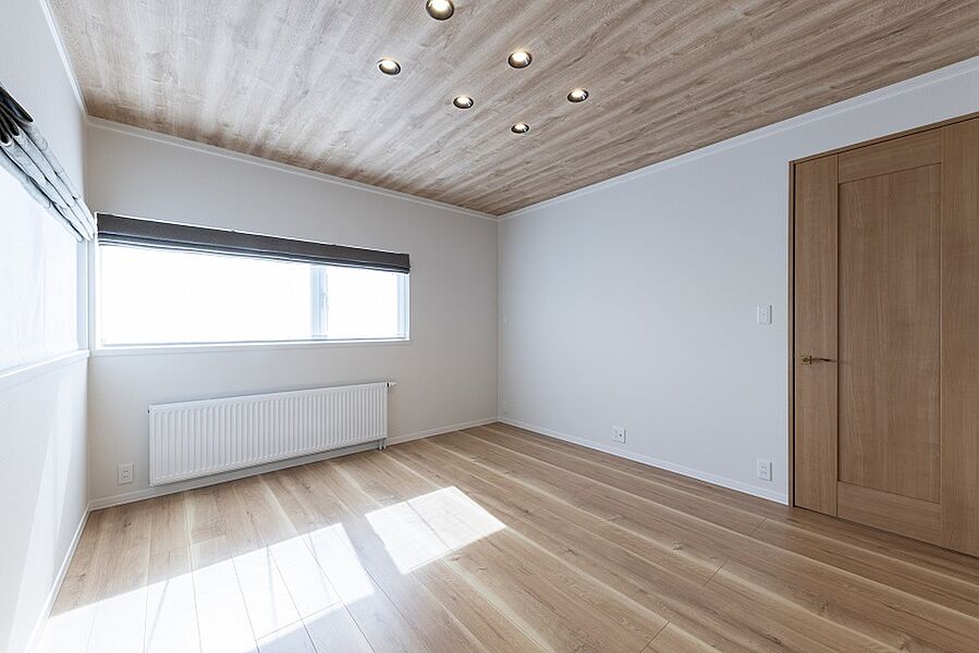 フローリングと天井に木目調を使用し、落ち着きのある主寝室