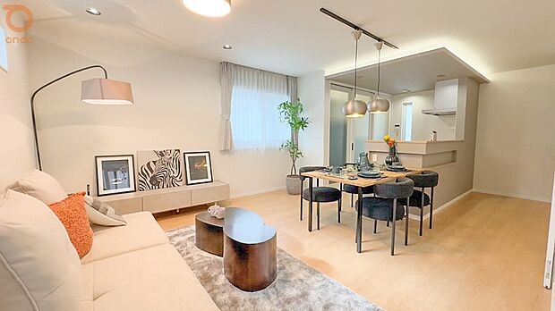 【ondo建物プラン例//LDK】やわらかな日差しが届く明るいLDK。淡い木目の床と落ち着いたトーンのキッチンが調和し、折り上げ天井の間接照明が空間に上品なアクセントを添えています。