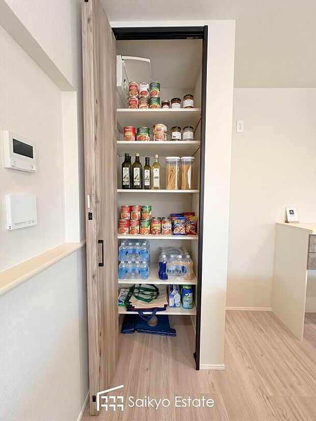 【パントリー（A号棟）】システムキッチンのすぐそばに配置したパントリー。ストック食品や調味料やお酒のほか、非常食や水のペットボトルなどの防災用品も収納できます。※備品・小物類はCG加工しています。