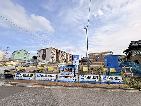 外観画像:造成中の分譲地の外観。整然とした区画と囲いがあり、前面道路は6mと広く駐車2台確保可能。周囲は低層住宅で落ち着いた住環境が期待でき、開放感があり暮らしやすい環境です。