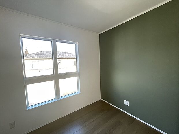 【4号棟 洋室】グリーンのアクセントクロスが特徴の洋室。遊び心ある色味ながら、落ち着いたグリーンでリラックスできる空間に。