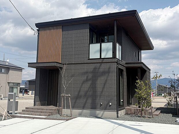 化粧格子がアクセントのブラック基調のA棟外観（2025年4月撮影）