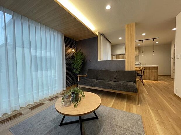 【リビング】アクセントクロスと間接照明でゆったり落ち着きのあるリビング。南側にLDKが並び北道路でも日当たり◎(2025年7月撮影)