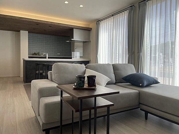 大きな窓からたっぷり光が差し込む、家族みんなでくつろげる広々とした空間。落ち着いたトーンの内装と木目調のキッチンがやさしく調和し、何気ない日常を少し贅沢に感じられる、心地よい時間が流れます。