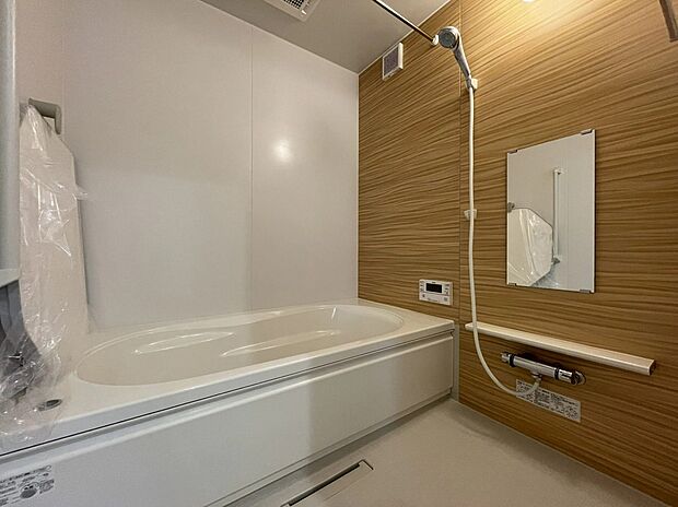 【3号地 浴室】木目調のアクセントパネルがやさしい雰囲気を演出するバスルーム。白を基調とした清潔感ある空間に、ゆったりとした浴槽でくつろげます。毎日の疲れを癒せる心地よい空間です。