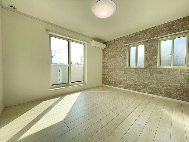 【主寝室】南側に配置された主寝室は、自然光がたっぷりと差し込む明るく心地よい空間。石目調のアクセントクロスが、落ち着きのあるモダンな雰囲気を演出します。1日の疲れを優しく癒やす、ゆとりのプライベートルームです。