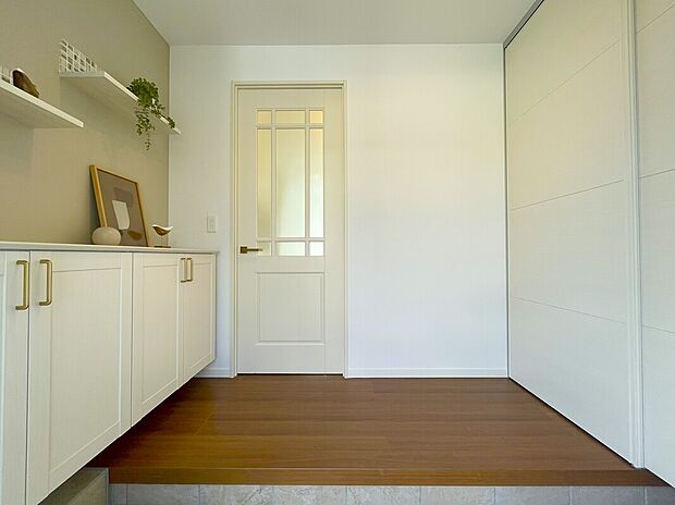 ベビーカーやアウトドア用品も収納できる、シューズクローク兼土間収納のある明るい玄関。