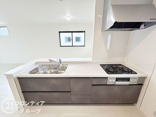 リビングとつながる対面式キッチンは、家族とコミュニケーションを取りながら調理ができる嬉しい設計。３口コンロや引き出し式収納など設備も充実。空間全体に開放感があり、明るく清潔な印象です。