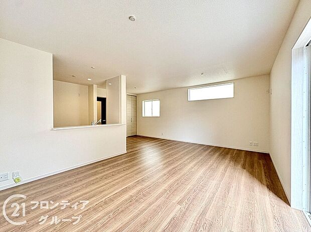 【リビング】ナチュラルな木目調のフローリングと落ち着いたトーンのクロスが調和したリビング。大きな掃き出し窓が開放感を演出し、外の風景と心地よくつながります。家族との時間も一人の時間も楽しめる理想的な居住空間です。