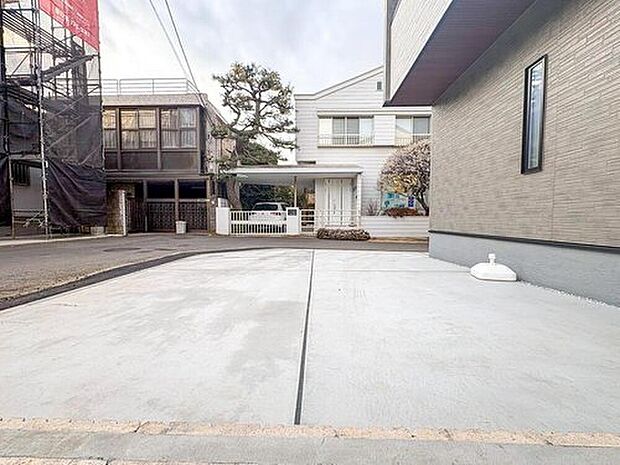 【駐車場】広々とした駐車スペースは、お子様の遊び場としても活躍。白い外壁と緑豊かな木々が調和し、家族の毎日を彩る穏やかな住環境です。