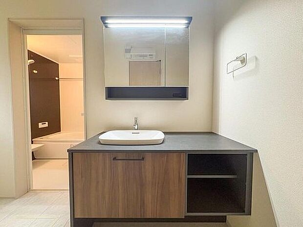 【洗面台・洗面所】デザイン性の高い洗面台は、毎日の身支度を快適にサポート。充実の収納で洗面周りもすっきり片付き、家族みんなで気持ちよく使えます。奥の浴室とも隣接し、家事動線もスムーズです。