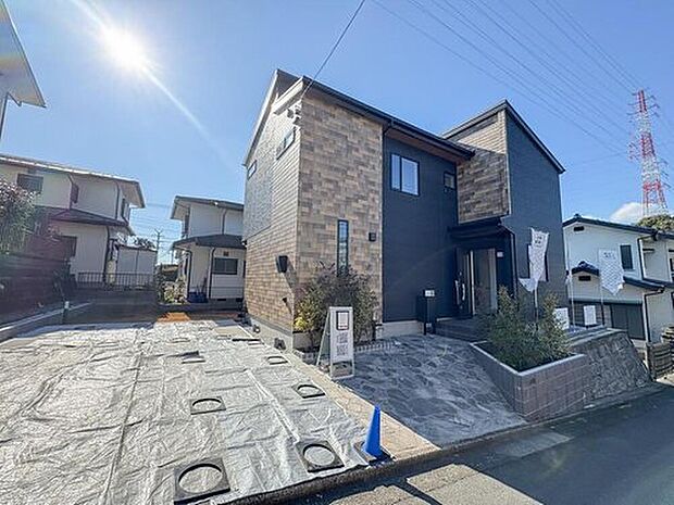 【現地外観写真】モダンなデザインと落ち着いた色合いが調和する外観。明るい陽射しが家族を迎え、心地よい毎日を彩ります。