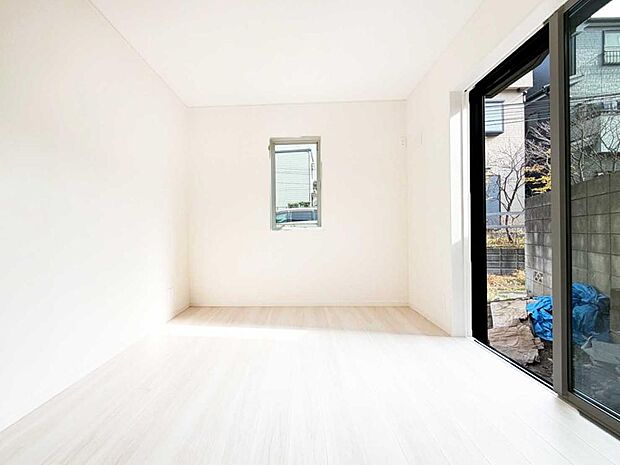 【リビング以外の居室】大きな掃き出し窓から柔らかな光が入る明るい洋室。家具が配置しやすいシンプルな形で、主寝室としてもゆったり使える落ち着いた空間です。
