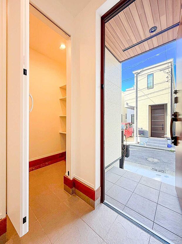 【玄関】木目天井とタイル仕上げが迎える、上質なエントランス。SICと一体で使いやすく、住まいの第一印象を高めます。