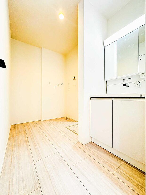 【洗面台・洗面所】明るく清潔感のある洗面室。洗濯機置場にゆとりがあり、家族で使っても窮屈さを感じにくい設計です。