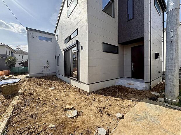 【【現地外観写真】】建設中のC棟は、青空に映える美しい外観がもうすぐお目見えします。この場所で育まれる家族の思い出を想像すると、胸が高鳴りますね。