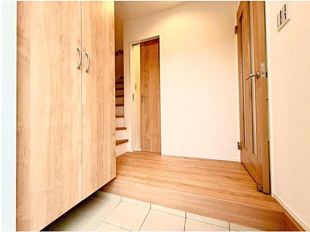 【玄関】明るい光が差し込む玄関は、家族を優しく迎え入れます。大容量のシューズボックスで、お子様の靴やベビーカーもすっきりと収納でき、いつも片付いた空間を保てます。