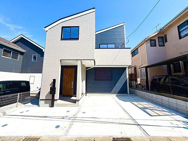 【現地外観写真】青空に映える、洗練されたデザインの住まいが完成しました。広々とした駐車スペースは、来客時にも便利で、家族のカーライフをサポートします。