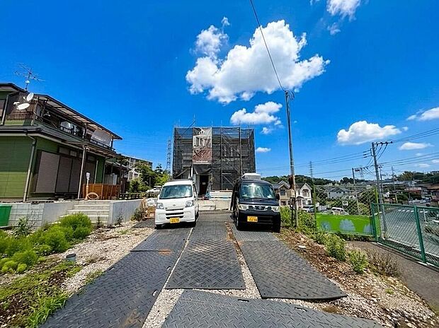 【現地外観写真】青空が広がる高ヶ坂の地に、家族の夢を育む新居が建設中。ゆとりの駐車スペースを備え、完成が待ち遠しいこの場所で、新しい家族の物語が始まります。