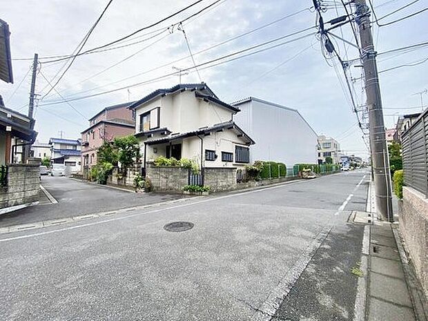【前面道路含む現地写真】≪現地（2026年7月）撮影≫東側4m私道に面した角地の外観写真。アスファルト舗装の前面道路と周辺住宅が確認できます。