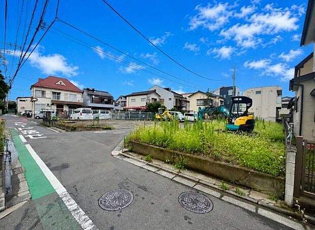 【前面道路含む現地写真】現地(2026年7月)撮影 造成中の区画と重機、周辺住宅が写る現地写真。西側6m公道・北側4m私道に面する角地です。