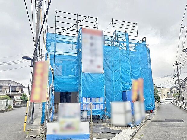 【現地外観写真】現地(2026年8月)撮影
青い養生シートで覆われた2棟の建築現場。南東側4m・南西側6mの公道に面し、完成予定は2026年10月です。