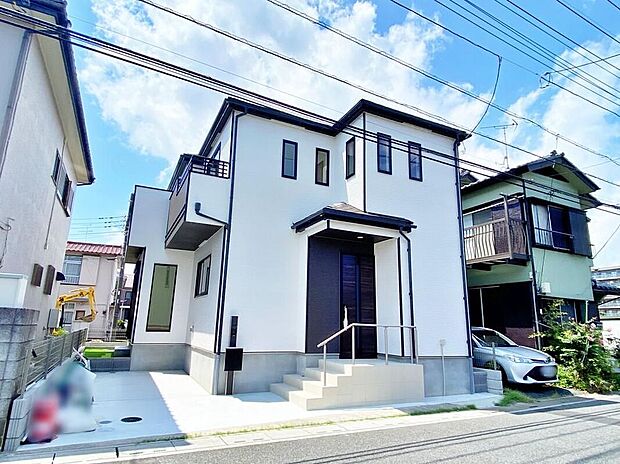 【現地外観写真】現地(2026年8月)撮影
白い外壁の木造2階建。玄関に階段と手すり、敷地90.79m2/建物93.15m2、駐車1台分のカースペース、東側幅員7.2mの公道に面しています。