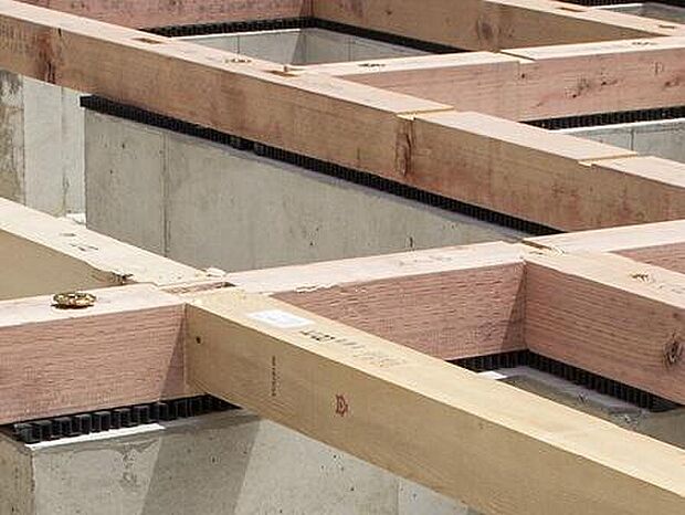 【足元を支える「ベタ基礎」】コンクリートで建物の下一面を支える工法。 基礎鉄筋を張り、強度を高めたベタ基礎の耐圧盤を1階の床下全面に施工し、広い耐圧盤の面で建物の荷重を地盤に伝えます。