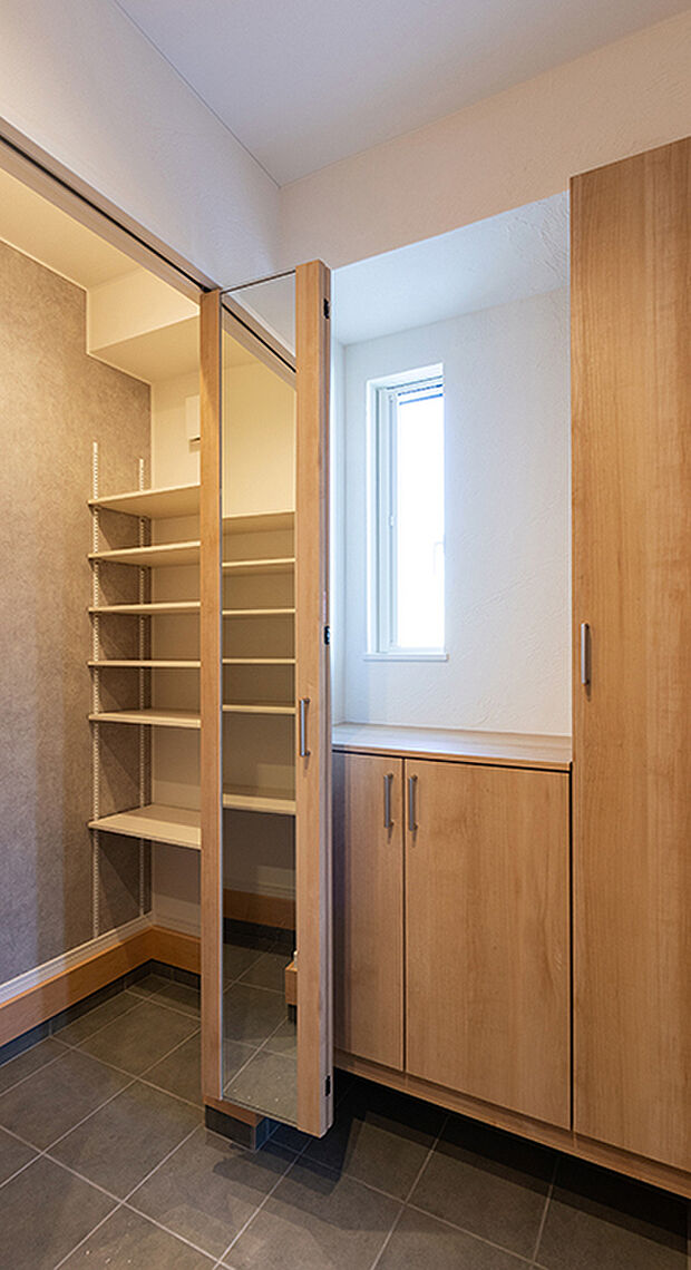 【-】【住まいの顔、玄関は玄関収納ですっきりと】
ゆったりとした玄関ホール。広い玄関は、家族全員で出かける際も、一斉に靴を履くことができて便利です。小さなお子様がいる家庭では、靴の脱ぎ履きに時間がかかる場合でも、親御さんがじっくりサポートでき、使い勝手がよくなります。姿見の付いた玄関収納は、可動棚の高さを調節することで、大きめのブーツなどもきれいに収まり、いつでもきれいな玄関を保てます。