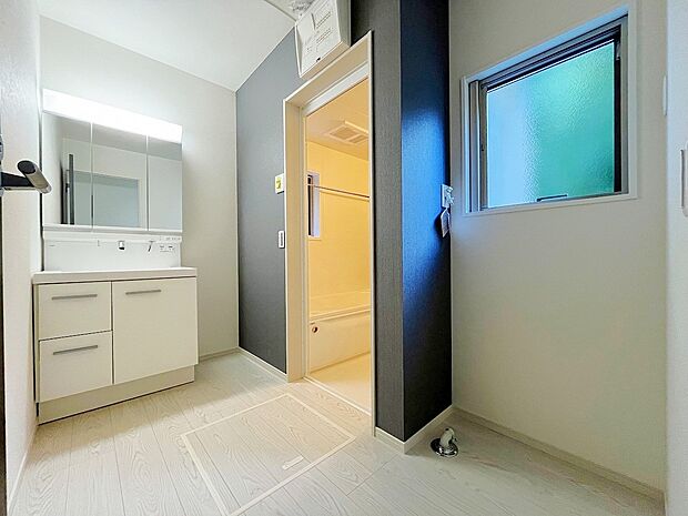 【洗面台・洗面所】鏡の裏に収納棚を確保した三面鏡を採用。小窓付きの洗面室は、毎朝心地よい光と爽やかな風を運んでくれます。お手入れしやすいシンプルな洗面化粧台は、鏡の裏も収納です。