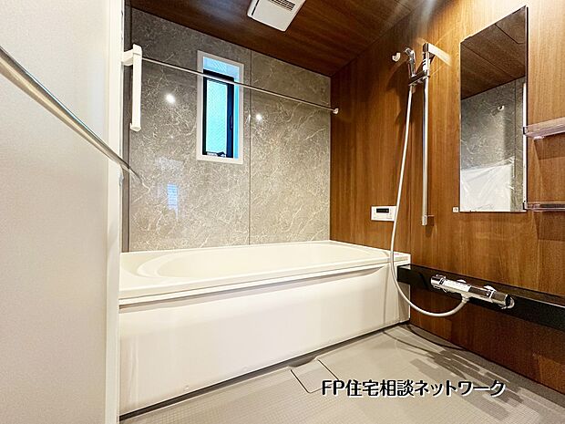 【浴室】木目調パネルと石目柄のアクセントが調和した、ホテルライクなバスルーム。落ち着いた雰囲気の中で、一日の疲れを癒す贅沢な時間を過ごせます。