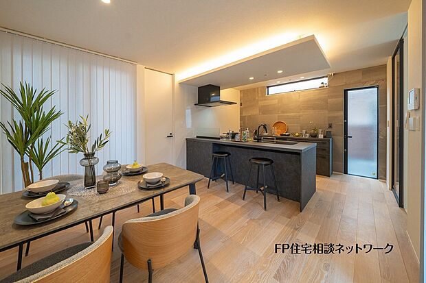 【プラン例　建物価格2480万円　建物面積100m2】対面キッチンと緩やかにつながるダイニング空間。間接照明がやさしく広がり、食事の時間を上質に演出します。