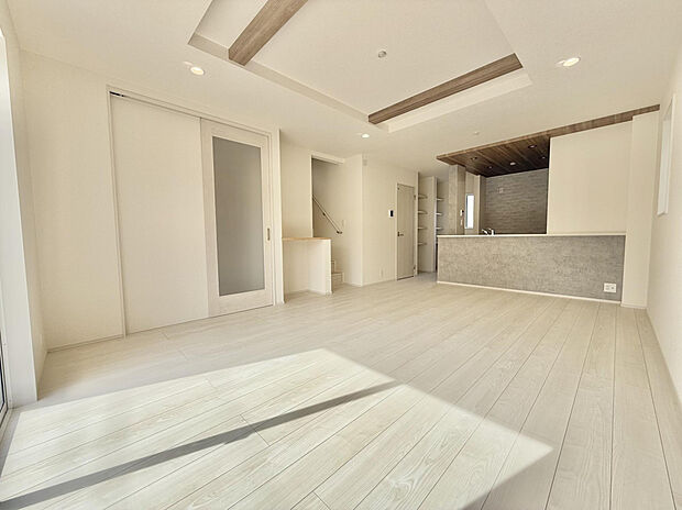 【リビング　(2)号棟】折り上げ天井を採用。天井に立体感を持たせることで、空間の広がりを感じられる設計。家族が集まるリビングを、より心地よい空間へと引き上げます。