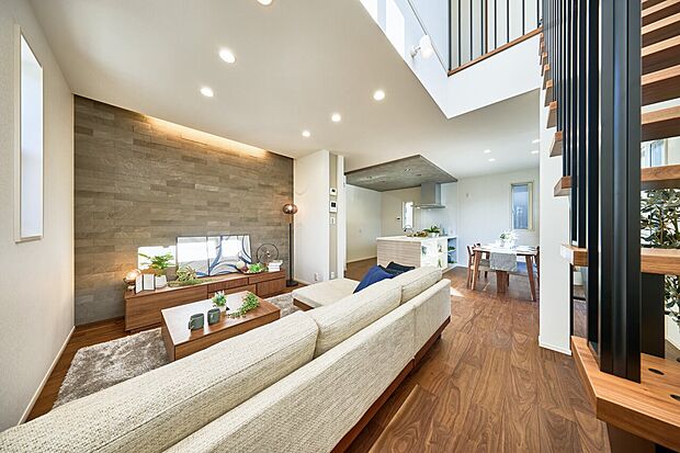 石目調のアクセントウォールを採用したリビング。間接照明が陰影をより映えさせ、上質な雰囲気に。(1号棟)