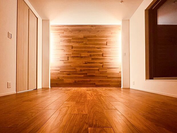 【寝室】【PLAN.09】寝室にはダイナミックな木目調のアクセントウォールを施しました。間接照明でより陰影が映え、ホテルライクな仕上がりに。（2024年4月撮影）