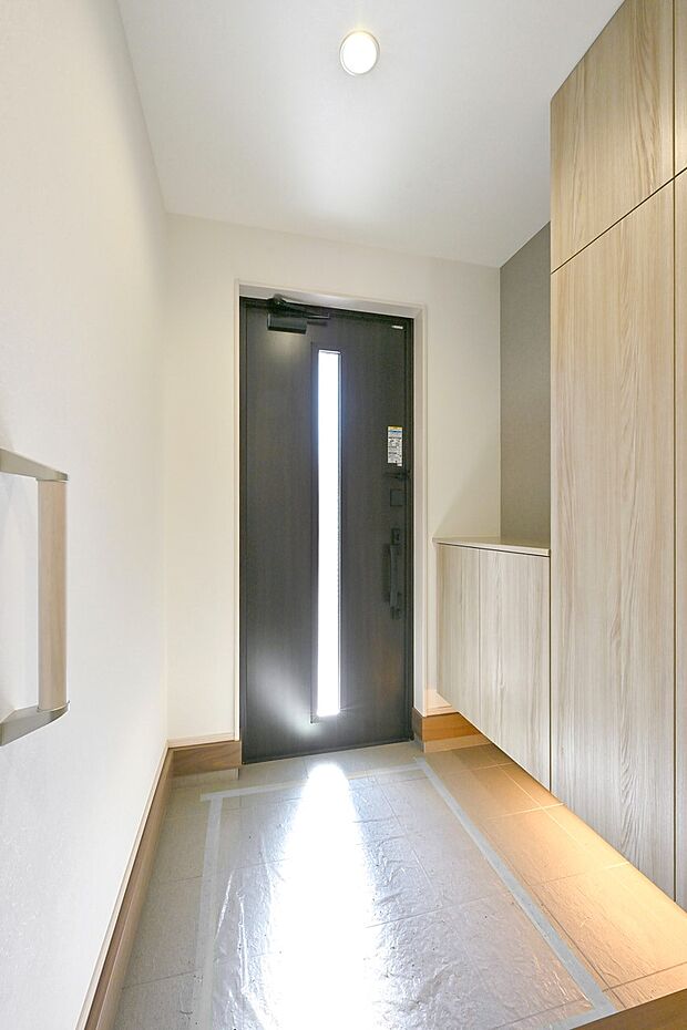 【玄関】スリット採光デザインの玄関ドアは光が入りやすく、明るい玄関に。(1号棟)
