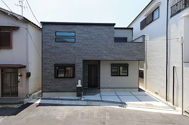 当社施工例(外観)
石目調のダークグレーと、明るいライトグレーを組み合わせたスタイリッシュな外観。直線的で無駄のないボックスシルエットが、都市の街並みの中で一際モダンな存在感を放ちます。