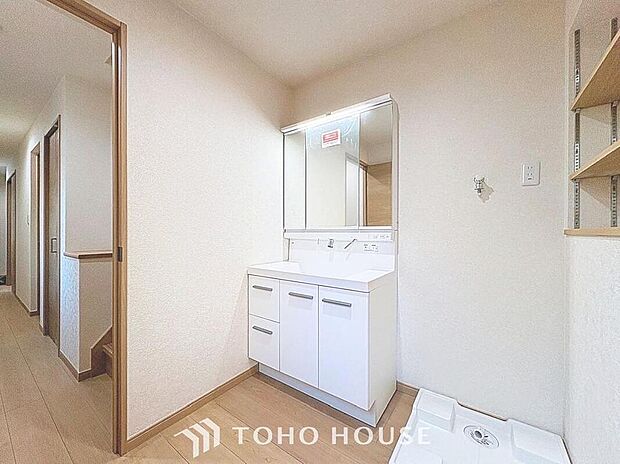 【洗面化粧台】
白を基調とした清潔感溢れるデザインの洗面化粧台です。三面鏡の裏側や足元のキャビネットなど、収納豊富で実用的な洗面空間です。