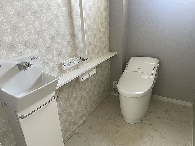 【1Fトイレ】1階トイレは節水型の多機能便座です。広々しているので圧迫感のないトイレになっています。手すりやバリアフリー構造など将来的にも安心して使用できるものになっています。独立した手洗いもご用意しています。