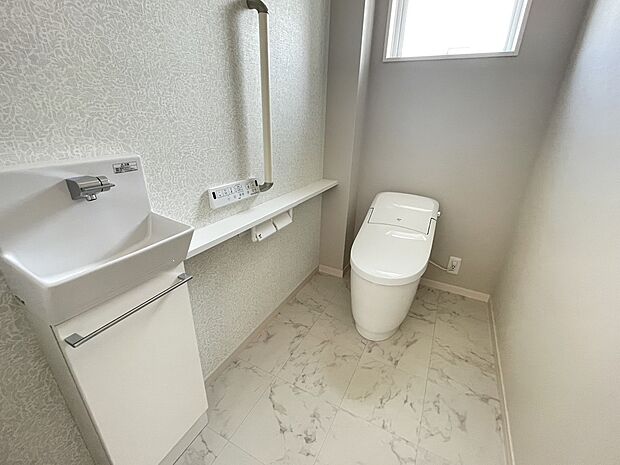 【1Fトイレ】1階トイレは節水型の多機能便座です。広々しているので圧迫感のないトイレになっています。手すりやバリアフリー構造など将来的にも安心して使用できるものになっています。独立した手洗いもご用意しています。
