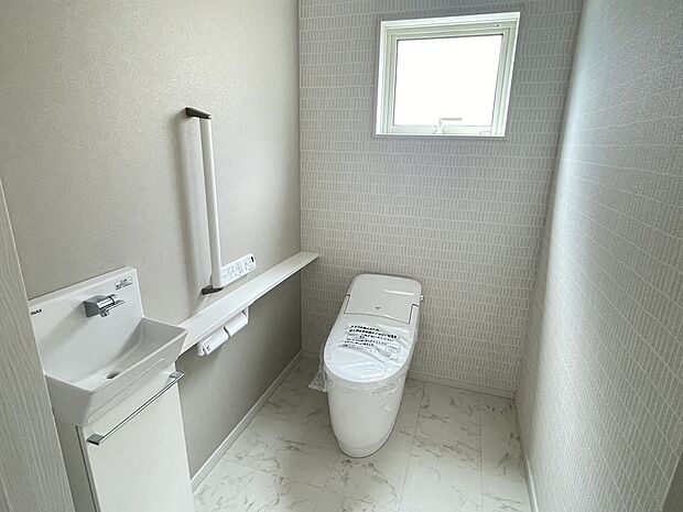 【1Fトイレ】1階トイレは節水型の多機能便座です。広々しているので圧迫感のないトイレになっています。手すりやバリアフリー構造など将来的にも安心して使用できるものになっています。独立した手洗いもご用意しています。
