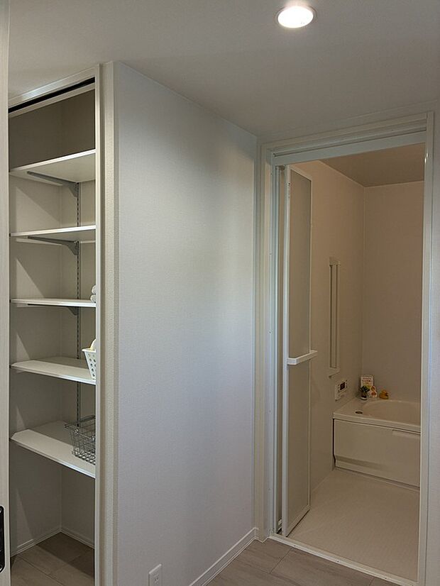 【洗面室の収納】浴室隣接の洗面室に棚付き収納を設置。タオルや着替え、洗剤類をすっきりまとめられ、入浴から身支度までの動線がスムーズに整います。