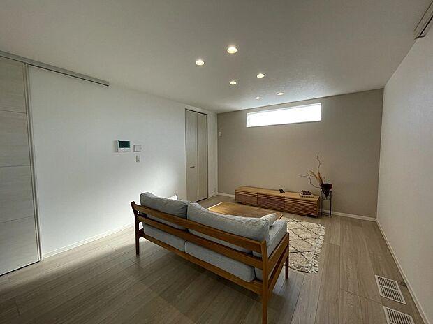 【リビング】TVボード上部には朝日を取り入れるためのFIX窓を設置。やわらかな光が室内に広がり、明るく開放的な空間を演出します。外からの視線にも配慮した配置です。